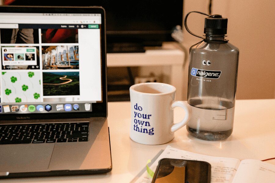 Lahev Nalgene na pracovním stole u macbooka. Zdroj: https://www.pexels.com/cs-cz/foto/kava-salek-notebook-internet-3959986/