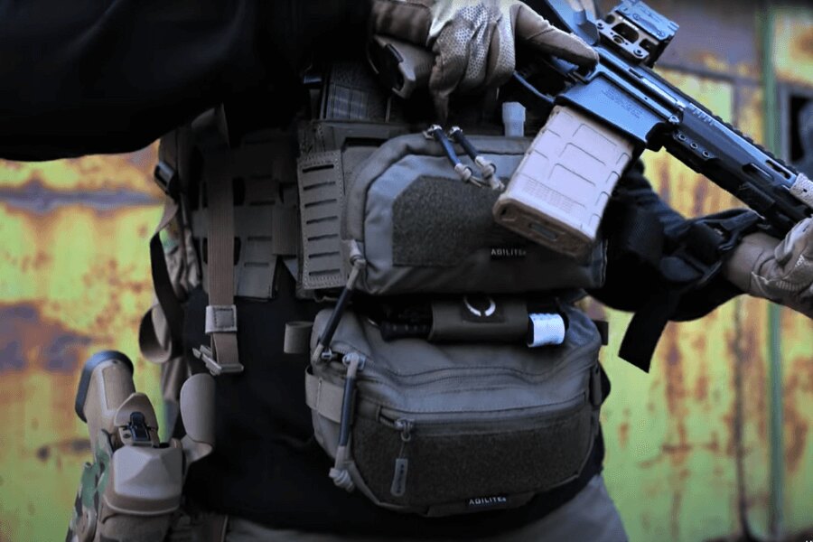 Muž s Chest Rig Reaper™ Agilite Gear® osazeným sumkama a s dlouhou zbraní. Zdroj: Rigad - video